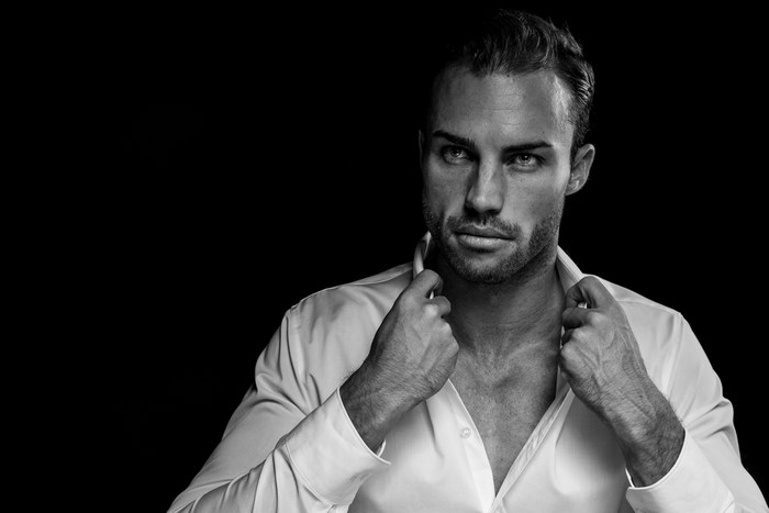 Man in white shirt adjusting collar