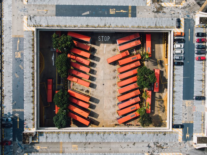 Aerial view of a bus parking lot with cars