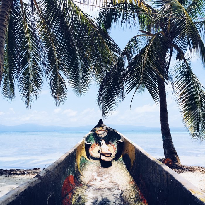 Canoe on a tropical beach with palm trees