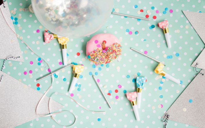 Birthday party with donut, balloon, and party blowers