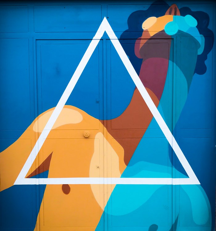 Graffiti art of a stylized body with a white triangle overlay