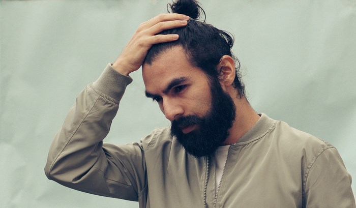 Man with beard and man bun wearing a jacket
