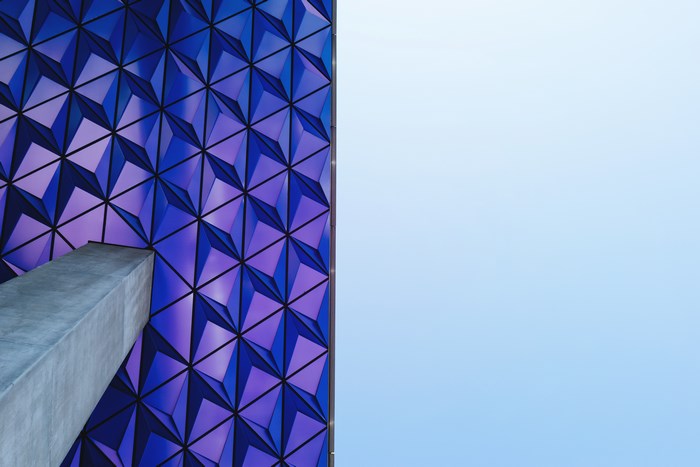 Geometric Facade and Concrete Column Against Blue Sky