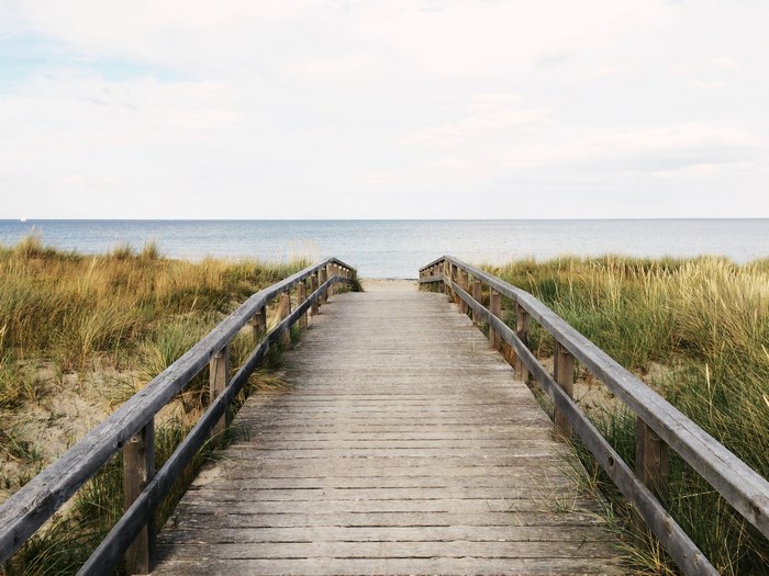 Wooden boardwalk through dunes to the ocean
