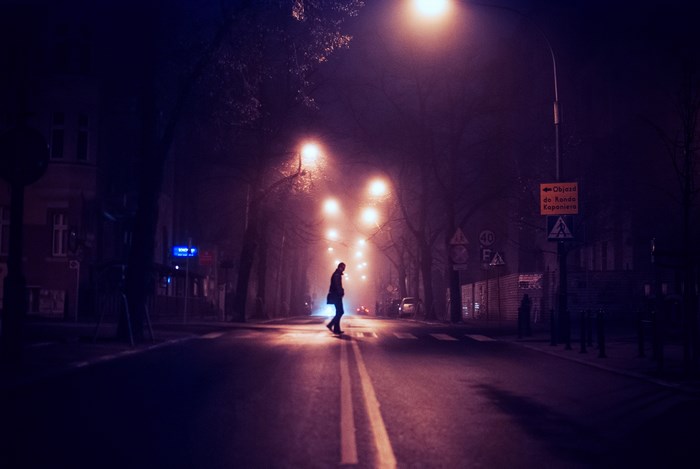 Man crossing street at night in foggy Poland