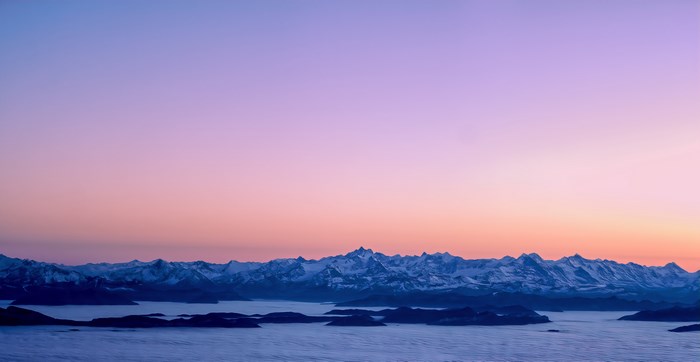 Mountain range at sunrise with clouds