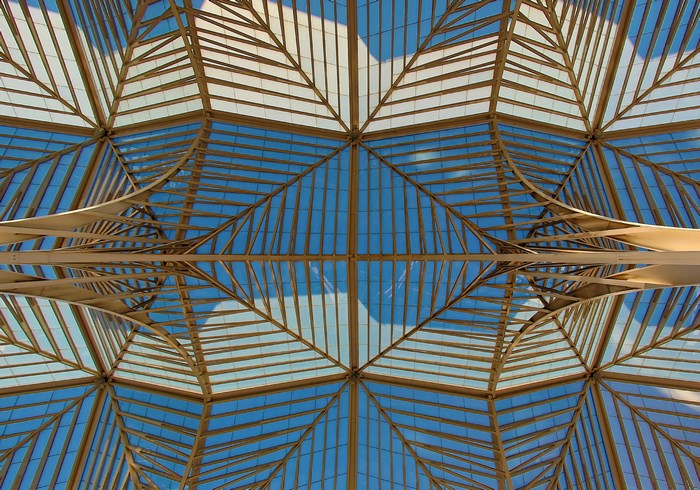 Geometric glass and steel roof structure looking up at the sky