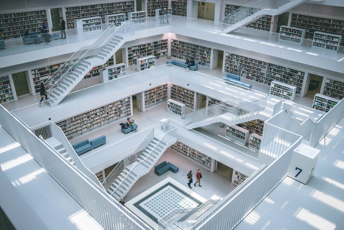 Interior of a modern library with white stairs and bookshelves