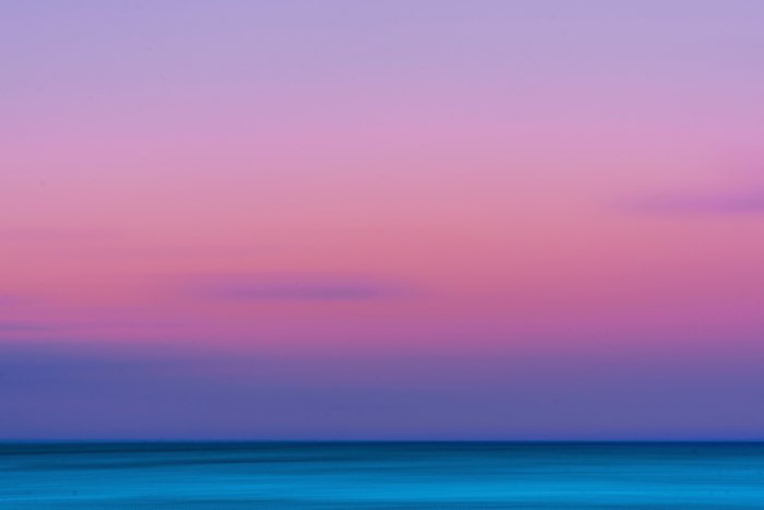 Blurry ocean horizon at sunset with pastel sky