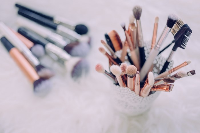 Collection of professional makeup brushes in a decorative holder