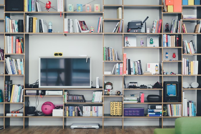 Organized bookshelf with books, TV, and decorative items