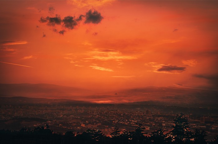 Cluj-Napoca city at sunset with orange sky and clouds