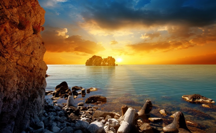 Sunset Over Rocky Shore with Calm Sea