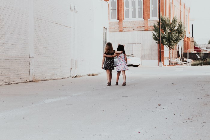 Two girls walking down a city street
