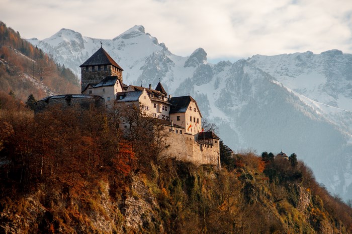 Castle Vaduz on a cliff with snowy mountains