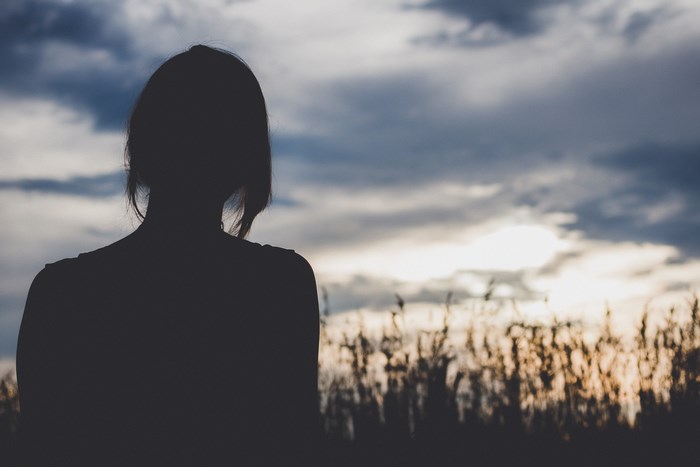 Silhouette of a woman looking at the sunset