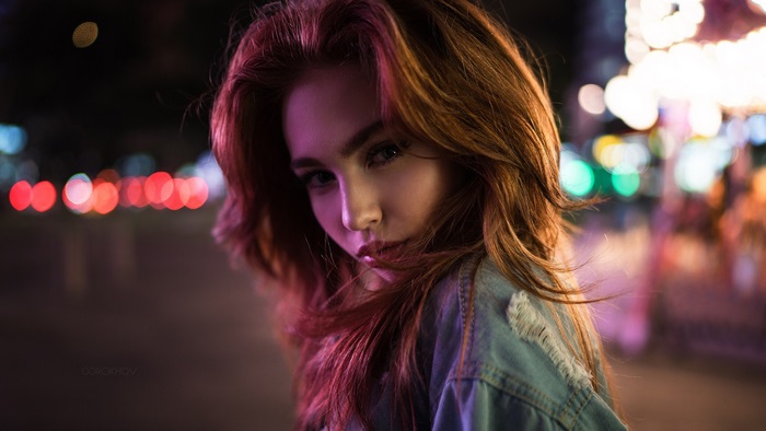 Girl with red hair in denim jacket at night