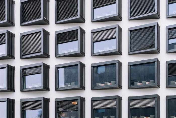 Modern building facade with geometric windows and blinds