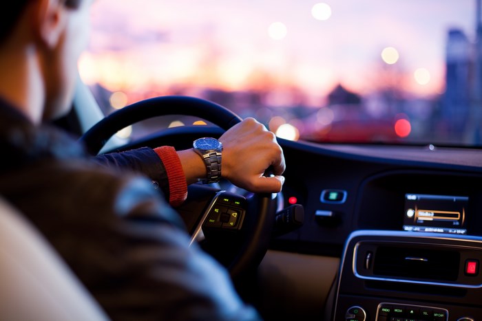 Man driving a car at night with bokeh lights