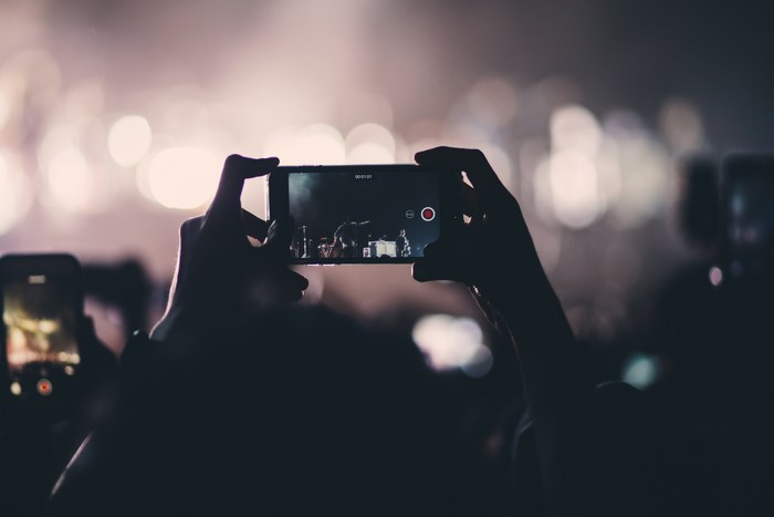Person recording a concert on a smartphone