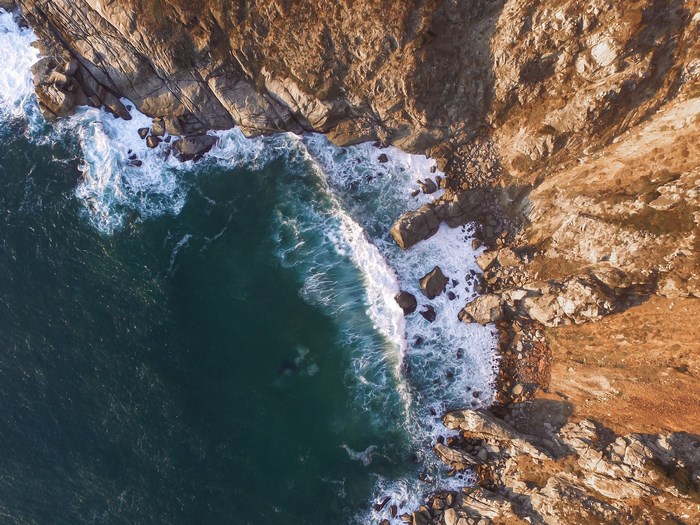 Aerial view of waves crashing on rocky cliffs in South Africa