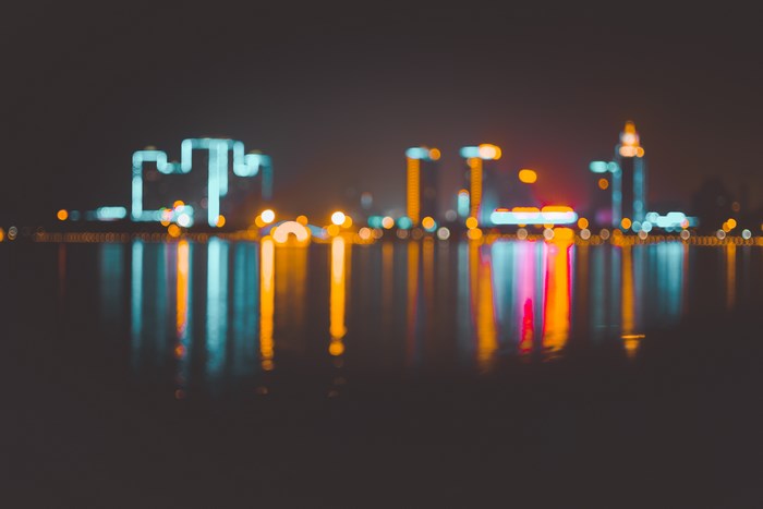 Cityscape with bokeh lights reflected on water at night