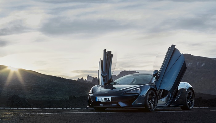 McLaren 570S with butterfly doors in a mountainous landscape