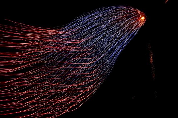 Long exposure of fireworks with red and blue light trails