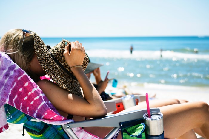 Woman relaxing on a beach chair by the ocean