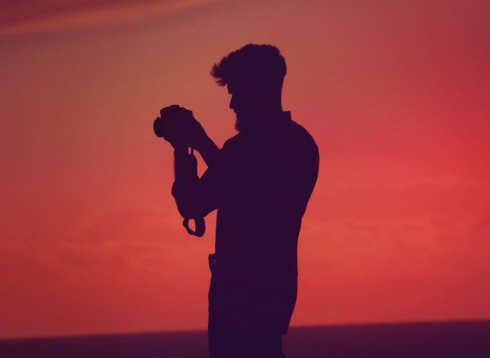 Silhouette of a man with a camera at sunset