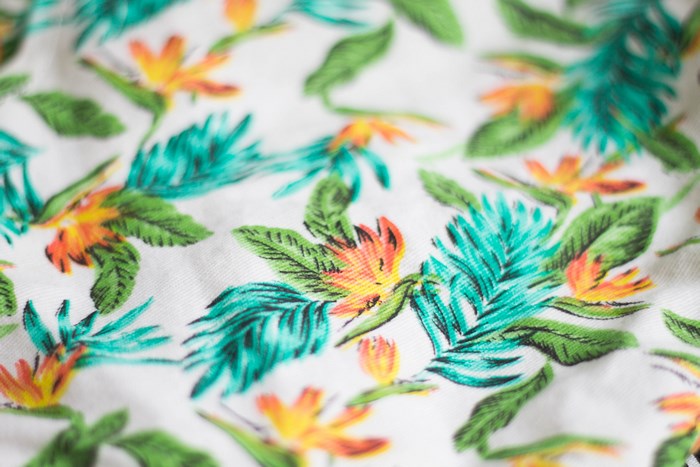 Tropical floral print fabric with green and orange flowers