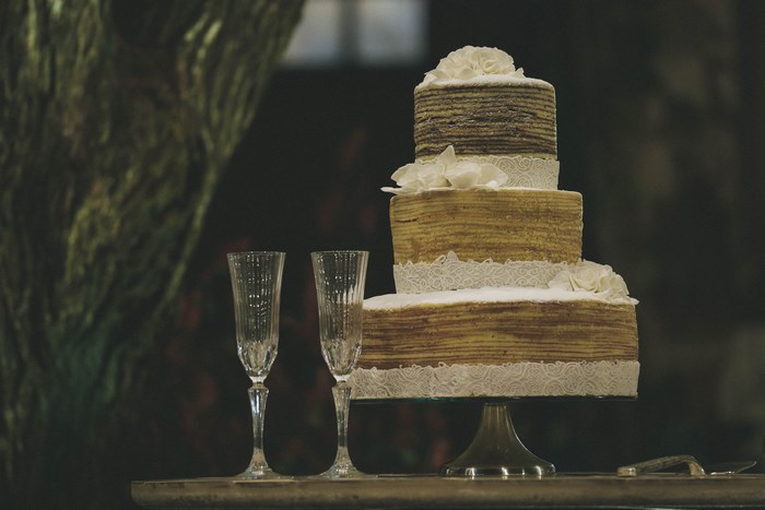 Three-tiered wedding cake with champagne flutes