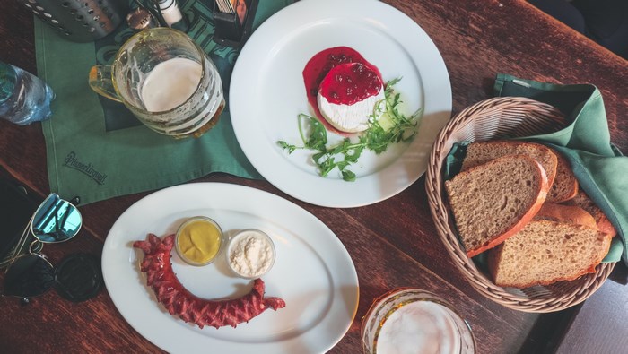 Sausage, cheese, bread, and beer on a table