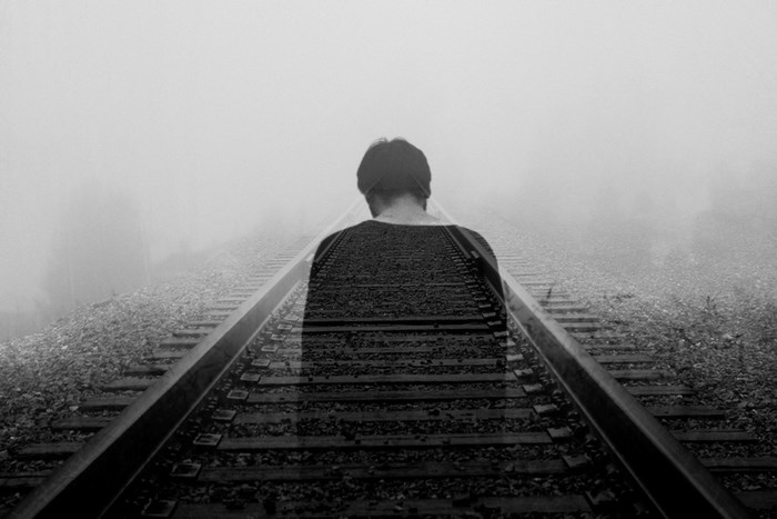 Silhouette of a Man on Foggy Train Tracks