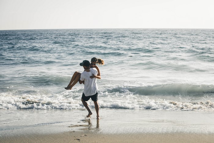 Couple playing in the ocean waves at the beach