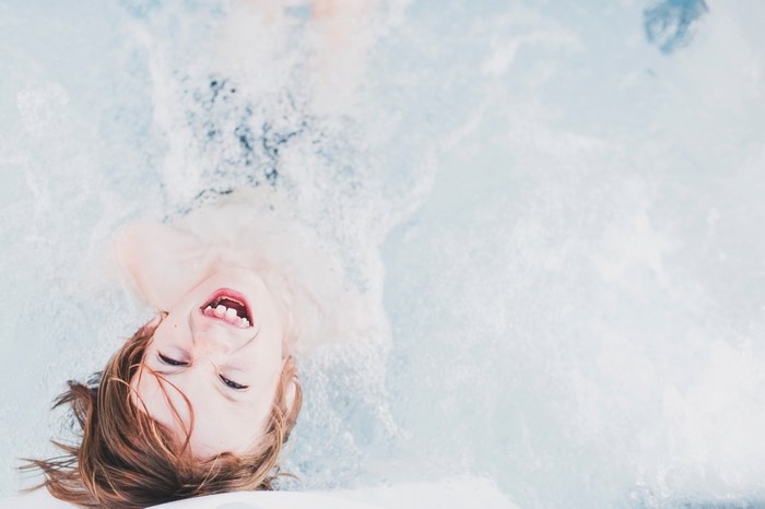 Child laughing in a bubbly pool