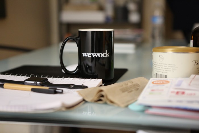 WeWork mug and Apple Watch on a desk