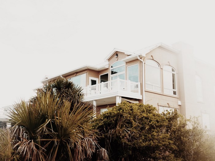 Peach-colored beach house with palm trees and balcony