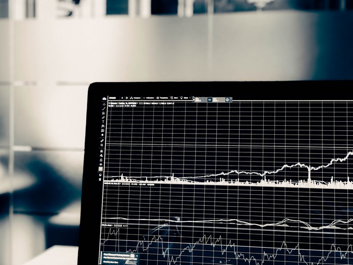 Close-up of a laptop screen displaying stock market graphs