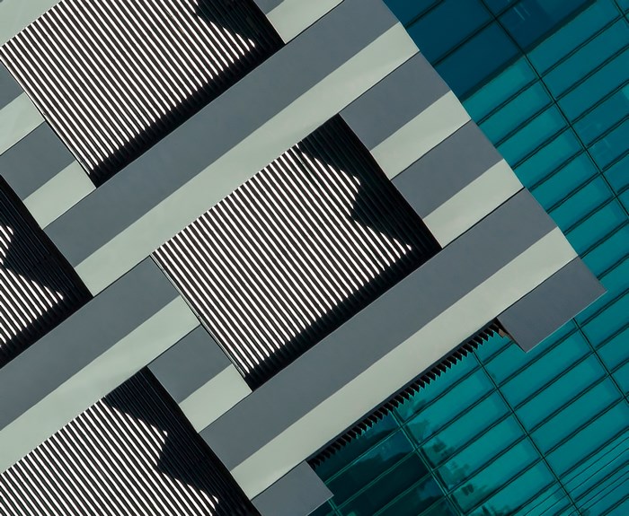 Modern building facade with geometric patterns and blue glass
