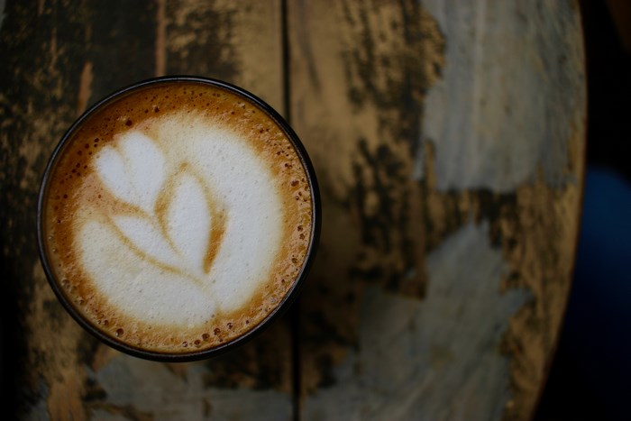 Latte with flower art on a wooden table