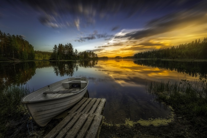 Boat docked on a lake at sunset 4K