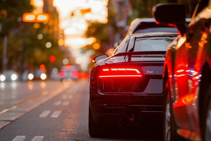 Audi R8 sports car in city traffic at sunset