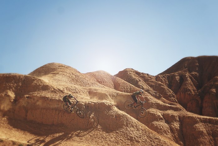 Mountain bikers riding down a desert terrain in Kyrgyzstan