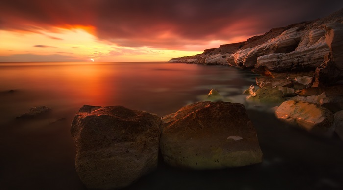 4K Sunset Over Calm Rocky Shoreline