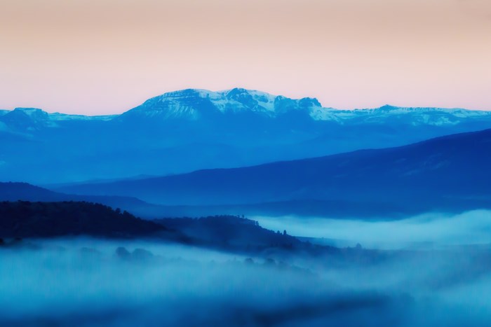 Misty blue mountain layers at sunset