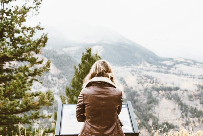 Woman in leather jacket looking at mountain view