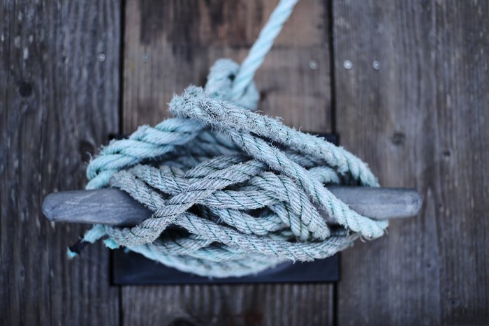 Rope tied to a cleat on a wooden dock