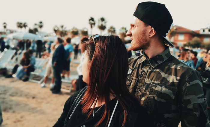 Couple wearing camouflage shirt and backwards cap at a festival