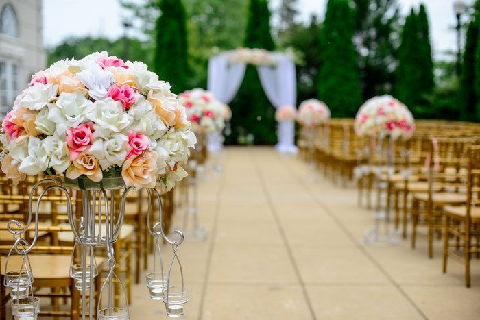 Outdoor wedding ceremony with floral arrangements and chairs